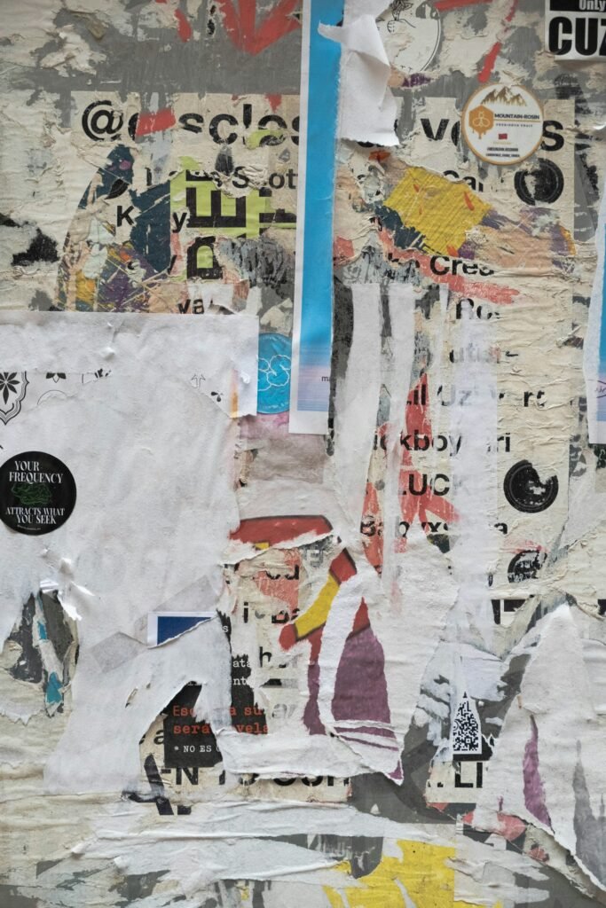 Weathered layers of torn posters, tape and flyers peeled from a single wall.